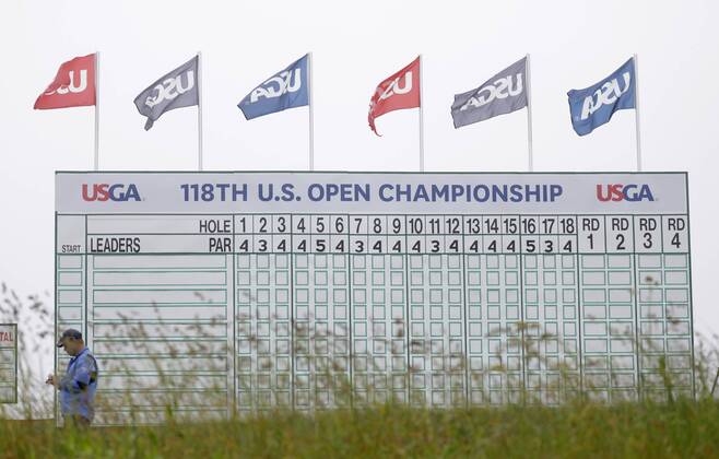 USGA flags fly above a leaderboard with no entries on it on the Wednesday before the 118th U.S. Open Championship at Shinnecock Hills Golf Club in Southampton, New York on June 13, 2018.  NYP20180613301A JOHNxANGELILLO