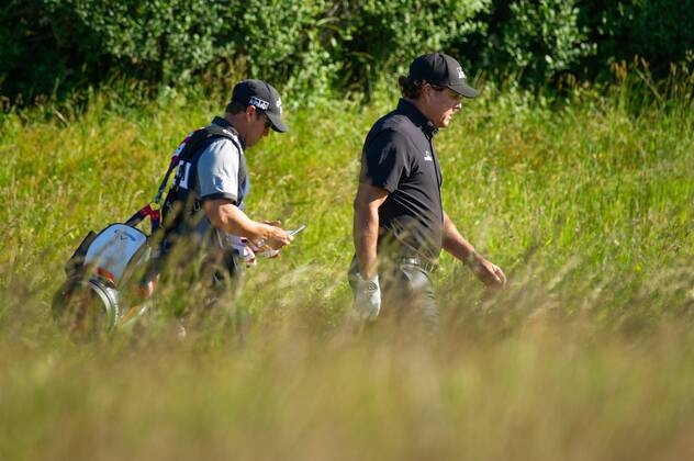 Phil Mickelson from the United States and caddy Tim Mickelson walk on the 10th fairway in the first round of the 118th U.S. Open Championship at Shinnecock Hills Golf Club in Southampton, New York on June 14, 2018.  NYP20180614110 COREYxSIPKIN