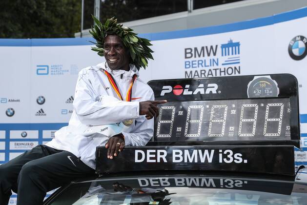 Sport Bilder des Tages (180916) -- BERLIN, Sept. 16, 2018 -- Kenya s Eliud Kipchoge poses for photos with the vehicle displaying his new world record during the Berlin Marathon 2018 in Berlin, capital of Germany, on Sept. 16, 2018. The Berlin Marathon 2018 kicked off in Berlin on Sunday. Eliud Kipchoge from Kenya won the men s title with a new world record of 2:01:39. Women s title fell on Kenya s Gladys Cherono with a result of 2:18:11. ) (SP)GERNAMY-BERLIN-BERLIN MARATHON 2018 ShanxYuqi 