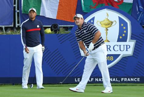 Patrick Reed, flanked byTiger Woods, hits his opening shot on the first tee at the start of the Ryder Cup at Le Golf National in Guyancourt near Paris on September 28, 2018. Team USA will compete against Team Europe in the three-day tournament.  PAR20180928086 DAVIDxSILPA