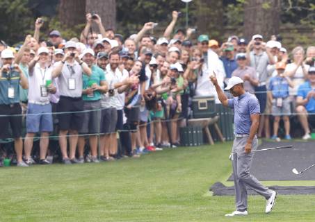 Fans react after Tiger Woods, Justin Thomas and Fred Couples skip balls across the water on the 16th green when they practice on the Monday before the 2019 Masters Tournament at Augusta National Golf Club in Augusta, Georgia, on April 8, 2019.  AUG20190408110 JOHNxANGELILLO