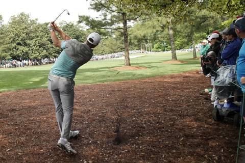 Dustin Johnson hits out of the pine straw with his 2nd shot on the first hole in the second round at the 2019 Masters Tournament at Augusta National Golf Club in Augusta, Georgia, on April 12, 2019.  AUG20190412105 JOHNxANGELILLO