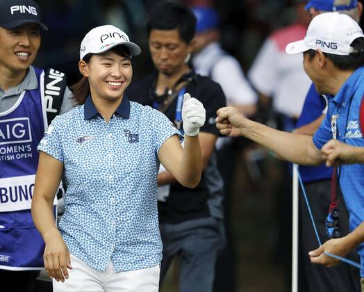 Golf: Women s British Open Hinako Shibuno of Japan gives a fist bump to a spectator as she walks to the 13th tee during the third round of the Women s British Open at Woburn Golf Club in Milton Keynes, England, on Aug. 3, 2019. Shibuno held a two-shot lead after 54 holes. 