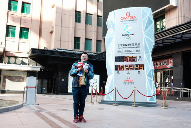 BEIJING, CHINA - FEBRUARY 04: A man holding mascot of Beijing 2022 Olympic Winter games, Winterspiele,Spiele, Summer games Bing Dwen Dwen and mascot of Beijing 2022 Paralympic Winter Games Shuey Rhon Rhon poses for a photo in front of a countdown clock for the Beijing 2022 Olympic Winter Games at the Wangfujing Street on February 4, 2021 in Beijing, China. China on Thursday marks the one-year countdown to the 2022 Winter Olympics, which will open on February 4 next year.  Copyright: xVCGx CFP111316009871 