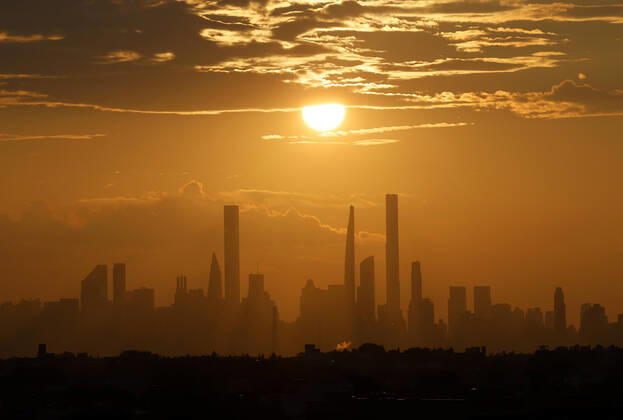 The sun sets behind the Manhattan skyline from Arthur Ashe Stadium in the first round of the 2021 US Open Tennis Championships at the USTA Billie Jean King National Tennis Center on Monday, August 30, 2021 in New York City.  NYP20210830151 JOHNxANGELILLO
