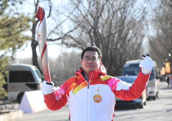 (220204) -- BEIJING, Feb. 4, 2022 -- Torch bearer Gong Weimi runs with the torch during the Beijing 2022 Olympic Torch Relay at the Grand Canal Forest Park in Beijing, capital of China, Feb. 4, 2022. ) (BEIJING2022)CHINA-BEIJING-OLYMPIC TORCH RELAY (CN) RenxChao 
