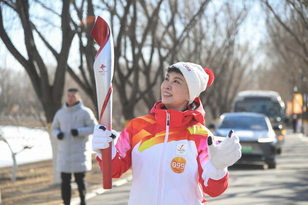 (220204) -- BEIJING, Feb. 4, 2022 -- Torch bearer Gong Lijun runs with the torch during the Beijing 2022 Olympic Torch Relay at the Grand Canal Forest Park in Beijing, capital of China, Feb. 4, 2022. ) (BEIJING2022)CHINA-BEIJING-OLYMPIC TORCH RELAY (CN) RenxChao 