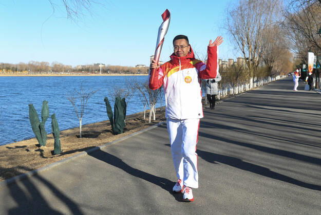 (220204) -- BEIJING, Feb. 4, 2022 -- Torch bearer Wang Tuo runs with the torch during the Beijing 2022 Olympic Torch Relay at the Grand Canal Forest Park in Tongzhou District of Beijing, capital of China, Feb. 4, 2022. ) (BEIJING2022)CHINA-BEIJING-OLYMPIC TORCH RELAY (CN) RenxChao 