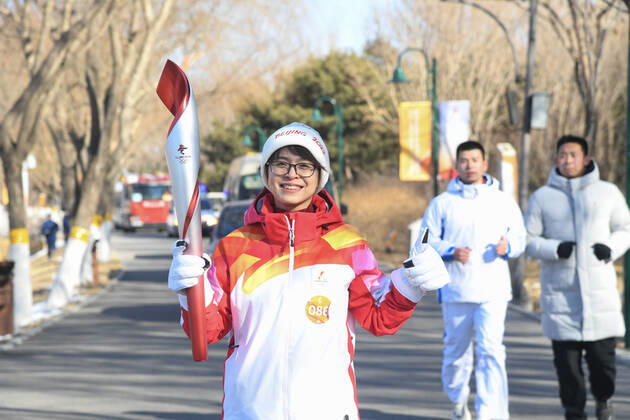 (220204) -- BEIJING, Feb. 4, 2022 -- Torch bearer Jia Xiaohong runs with the torch during the Beijing 2022 Olympic Torch Relay at the Grand Canal Forest Park in Tongzhou District of Beijing, capital of China, Feb. 4, 2022. ) (BEIJING2022)CHINA-BEIJING-OLYMPIC TORCH RELAY (CN) RenxChao 