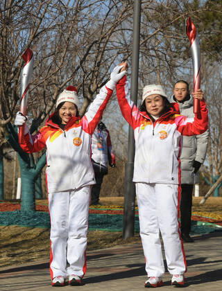 (220204) -- BEIJING, Feb. 4, 2022 -- Torch bearers Wang Caihong (R) and She Meng attend the Beijing 2022 Olympic Torch Relay at the Grand Canal Forest Park in Tongzhou District of Beijing, capital of China, Feb. 4, 2022. ) (BEIJING2022)CHINA-BEIJING-OLYMPIC TORCH RELAY (CN) RenxChao 
