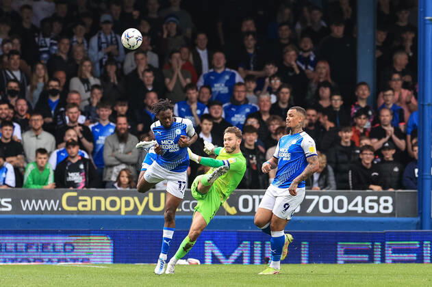 Sky Bet Championship Peterborough v Blackpool Chris Maxwell 1 of Blackpool clears the ball under pressure from Ricky Jade-Jones 17 of Peterborough United Peterborough Weston Homes Stadium Cambridgeshire United Kingdom Copyright: xMarkxCosgrove NewsxImagesx