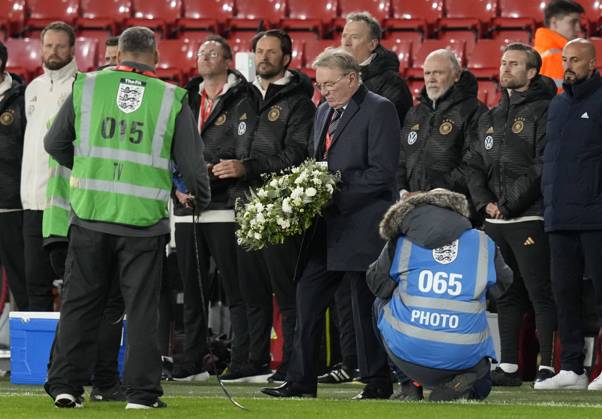 Sheffield, England, 27th September 2022. Former Sheffield Utd and England player Tony Currie lays a wreath in remembrance of Her Majesty the Queen ll during the International Friendly, Länderspiel, Nationalmannschaft match at Bramall Lane, Sheffield. Picture credit should read: Andrew Yates Sportimage EDITORIAL USE ONLY. No use with unauthorised audio, video, data, fixture lists, club league logos or live services. Online in-match use limited to 120 images, no video emulation. No use in betting, games or single club league player publications. SPI-1910-0015