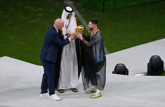 FOOTBALL World Cup 2022 Final Argentina France 18 12 2022 Lionel Messi in cape Bischt receives the World Cup trophy from Tamim bin Hamad Al Thani Emir of Qatar and Fifa President Gianni Infantino