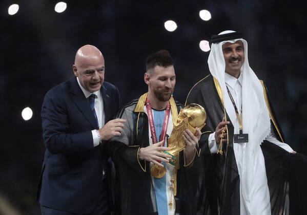 Lionel Messi (C) from Argentina poses with the World Cup trophy together with FIFA President Giovanni Vincenzo (L) and the Emir of the State of Qatar in the final of the FIFA World Cup, WM, Weltmeisterschaft, Fussball soccer tournament between Argentina and France at Lusail stadium in Lusail, Qatar, 18 December 2022. Soccer World Cup 2022: Argentina - France !ACHTUNG: NUR REDAKTIONELLE NUTZUNG! Copyright: xJuanxIgnacioxRoncoronix GR7388 20221218-d6f3a80e8ded01e8d27636f728970343807a9650