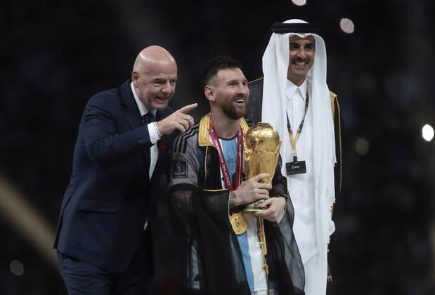 Lionel Messi (C) from Argentina poses with the World Cup trophy together with FIFA President Giovanni Vincenzo (L) and the Emir of the State of Qatar in the final of the FIFA World Cup, WM, Weltmeisterschaft, Fussball soccer tournament between Argentina and France at Lusail stadium in Lusail, Qatar, 18 December 2022. Soccer World Cup 2022: Argentina - France !ACHTUNG: NUR REDAKTIONELLE NUTZUNG!  Copyright: xJuanxIgnacioxRoncoronix GR7407 20221218-59e6aede2803dc595adae9f9a2be5299231e2b11