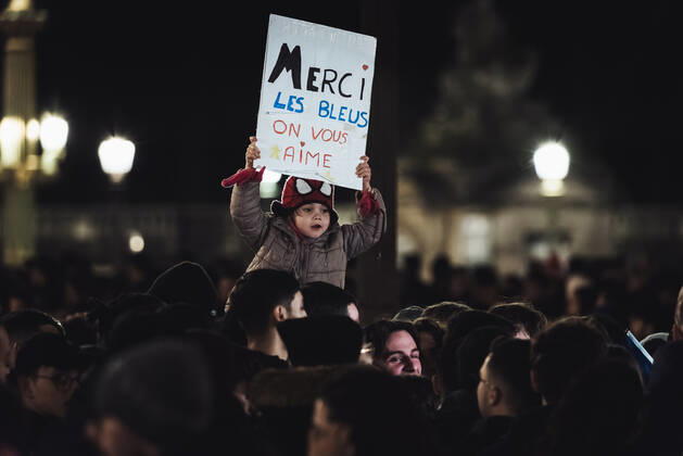 French Football Team Fans Greet The Players On The Place De La Concorde In Paris A child supporter of the French football team holds up a sign reading Merci les bleus (Thank you France) as a crowd gathers on the Place de la Concorde to welcome the players on the balcony of the Crillon hotel after their return from Qatar after their defeat by Argentina in the World Cup final in Paris December 19, 2022. Paris France  Copyright: xSamuelxBoivinx originalFilename:boivin-frenchfo221219_npIua.jpg