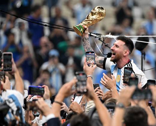 Football, men, season 2022 23, World Cup in Qatar, final, Argentina France 2 2, 3 3 n V, 4 2 i E at Lusail Iconic Stadium in Lusail, Lionel Messi Argentina with trophy, he is carried on shoulders long after the end of the game in the area behind the goal, he is photographed and filmed by fans with cell phones, cheering after the final whistle, 18 12 2022, Copyright: xMatthiasxKochx