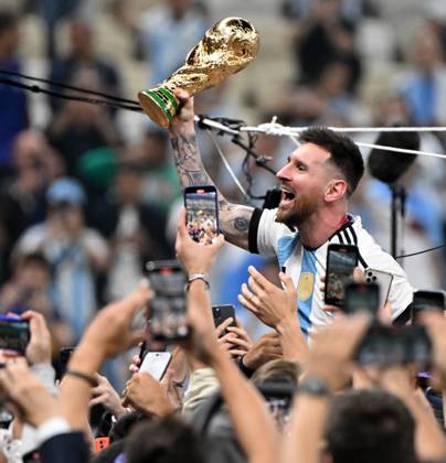 Football, men, season 2022 23, World Cup in Qatar, final, Argentina France 2 2, 3 3 n V, 4 2 i E at Lusail Iconic Stadium in Lusail, Lionel Messi Argentina with trophy, he is carried on shoulders long after the end of the game in the area behind the goal, he is photographed and filmed by fans with cell phones, cheering after the final whistle, 18 12 2022, Copyright: xMatthiasxKochx