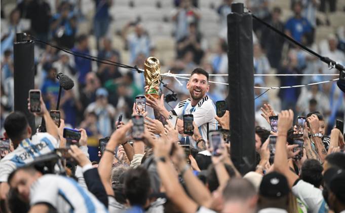 Football, men, season 2022 23, World Cup in Qatar, final, Argentina France 2 2, 3 3 n V, 4 2 i E at Lusail Iconic Stadium in Lusail, Lionel Messi Argentina with trophy, he is carried on shoulders long after the end of the game in the area behind the goal, he is photographed and filmed by fans with cell phones, cheering after the final whistle, 18 12 2022, Copyright: xMatthiasxKochx