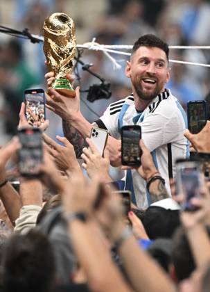 Football, men, season 2022 23, World Cup in Qatar, final, Argentina France 2 2, 3 3 n V, 4 2 i E at Lusail Iconic Stadium in Lusail, Lionel Messi Argentina with trophy, he is carried on shoulders long after the end of the game in the area behind the goal, he is photographed and filmed by fans with cell phones, cheering after the final whistle, 18 12 2022, Copyright: xMatthiasxKochx