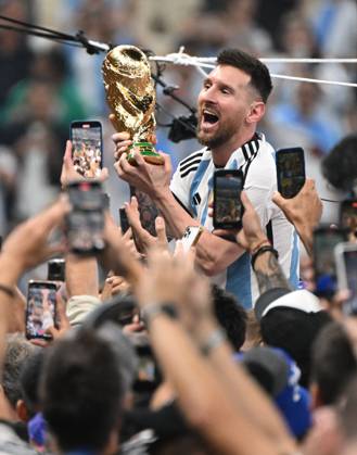 Football, men, season 2022 23, World Cup in Qatar, final, Argentina France 2 2, 3 3 n V, 4 2 i E at Lusail Iconic Stadium in Lusail, Lionel Messi Argentina with trophy, he is carried on shoulders long after the end of the game in the area behind the goal, he is photographed and filmed by fans with cell phones, cheering after the final whistle, 18 12 2022, Copyright: xMatthiasxKochx
