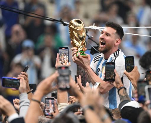 Football, men, season 2022 23, World Cup in Qatar, final, Argentina France 2 2, 3 3 n V, 4 2 i E at Lusail Iconic Stadium in Lusail, Lionel Messi Argentina with trophy, he is carried on shoulders long after the end of the game in the area behind the goal, he is photographed and filmed by fans with cell phones, cheering after the final whistle, 18 12 2022, Copyright: xMatthiasxKochx