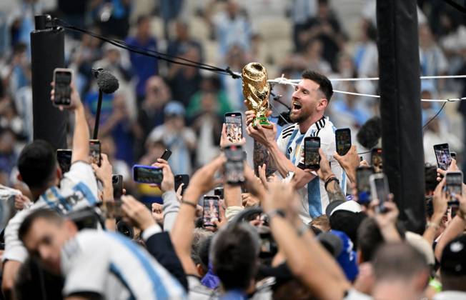 Football, men, season 2022 23, World Cup in Qatar, final, Argentina France 2 2, 3 3 n V, 4 2 i E at Lusail Iconic Stadium in Lusail, Lionel Messi Argentina with trophy, he is carried on shoulders long after the end of the game in the area behind the goal, he is photographed and filmed by fans with cell phones, cheering after the final whistle, 18 12 2022, Copyright: xMatthiasxKochx