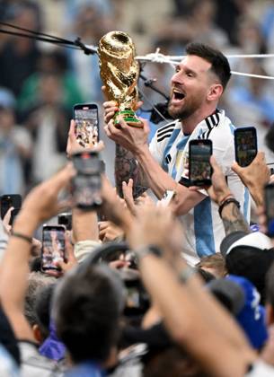 Football, men, season 2022 23, World Cup in Qatar, final, Argentina France 2 2, 3 3 n V, 4 2 i E at Lusail Iconic Stadium in Lusail, Lionel Messi Argentina with trophy, he is carried on shoulders long after the end of the game in the area behind the goal, he is photographed and filmed by fans with cell phones, cheering after the final whistle, 18 12 2022, Copyright: xMatthiasxKochx