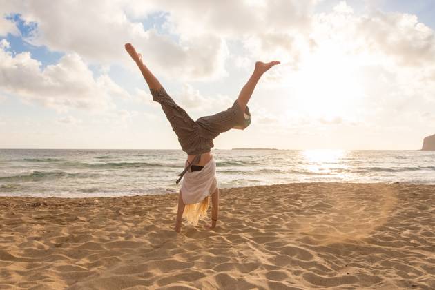 Free Happy Woman Turning Cartwheel Enjoying Sunset on Sandy Beach. Relaxed woman enjoying sun, freedom and life turning cartwheel on beautiful beach in sunset. Young lady feeling free, relaxed and happy. Vacations, freedom, happiness, enjoyment and well being. (License=RF) 10732286 Copyright: xZoonar.com MatejxKastelicx 10732286 ,model released, Symbolfoto ,property released