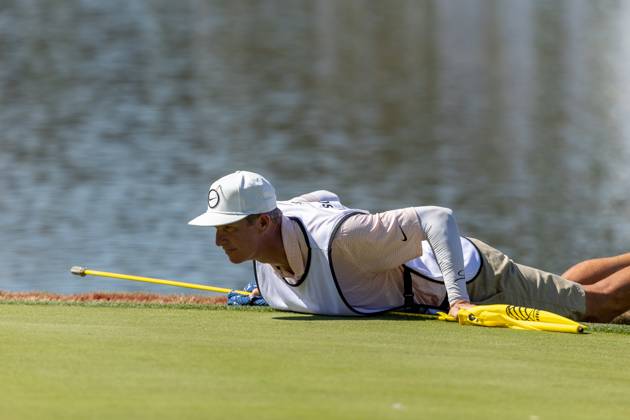AUSTIN, TX - MARCH 25: Ted Scott, Scottie Scheffler s caddie, lies on the ground of the 13th green to read a birdie putt during the Quarterfinals of the PGA, Golf Herren World Golf Championships Dell Technologies Match Play on March 25, 2023, at Austin County Club in Austin, TX. (Photo by David Buono Icon Sportswire) GOLF: MAR 25 PGA - World Golf Championships-Dell Technologies Match Play Icon230325075