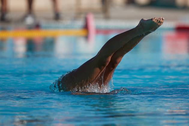 TAL-QROQQ, MALTA, 29 APRIL 2023: The legs of Malta national team, Nationalteam artistic swimmer Ana Culic (mostly submerged), point sideways out of the water during her artistic swimming performance at the National Pool, Tal-Qroqq, Malta on 29 April 2023. Ana Culic - Malta Artistic Swimmer AQUA_MAS_2023