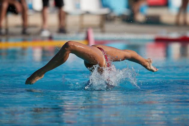 TAL-QROQQ, MALTA, 29 APRIL 2023: The legs of Malta national team, Nationalteam artistic swimmer Ana Culic (mostly submerged), point sideways out of the water during her artistic swimming performance at the National Pool, Tal-Qroqq, Malta on 29 April 2023. Ana Culic - Malta Artistic Swimmer AQUA_MAS_2023