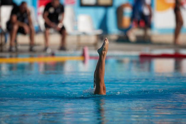 TAL-QROQQ, MALTA, 29 APRIL 2023: The legs of Malta national team, Nationalteam artistic swimmer Ana Culic (mostly submerged), point up out of the water during her artistic swimming performance at the National Pool, Tal-Qroqq, Malta on 29 April 2023. Ana Culic - Malta Artistic Swimmer AQUA_MAS_2023