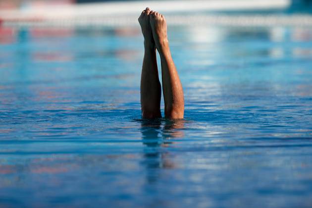 TAL-QROQQ, MALTA, 29 APRIL 2023: The legs of Malta national team, Nationalteam artistic swimmer Ana Culic (mostly submerged), point up out of the water during her artistic swimming performance at the National Pool, Tal-Qroqq, Malta on 29 April 2023. Ana Culic - Malta Artistic Swimmer AQUA_MAS_2023