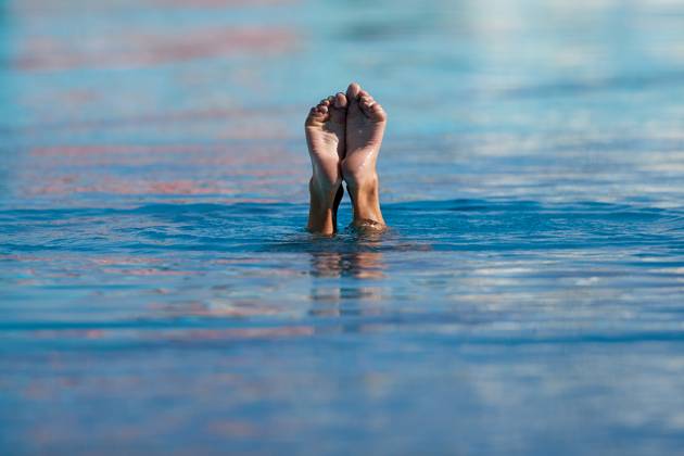 TAL-QROQQ, MALTA, 29 APRIL 2023: The legs of Malta national team, Nationalteam artistic swimmer Ana Culic (mostly submerged), point upwards out of the water during her artistic swimming performance at the National Pool, Tal-Qroqq, Malta on 29 April 2023. Ana Culic - Malta Artistic Swimmer AQUA_MAS_2023