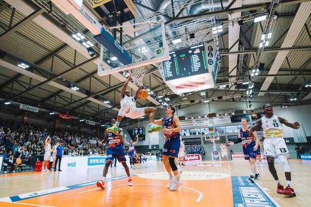 BARMER 2 Basketsball Bundesliga ProA season 2023 2024 3 matchday on 15 10 23 Medipolis SC Jena vs Phoenix Hagen center Rasheed Moore Jena with the fat dunk against two opponents, right celebrates teammate Amir Hinton Jena Sparkassen Arena Jena