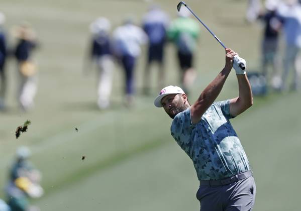 Spain s Jon Rahm hits his approach shot on the first hole in the second round of the Masters Tournament at Augusta National Golf Club in Augusta, Georgia on Friday, April 12, 2024.  AUG20240412115 JOHNxANGELILLO