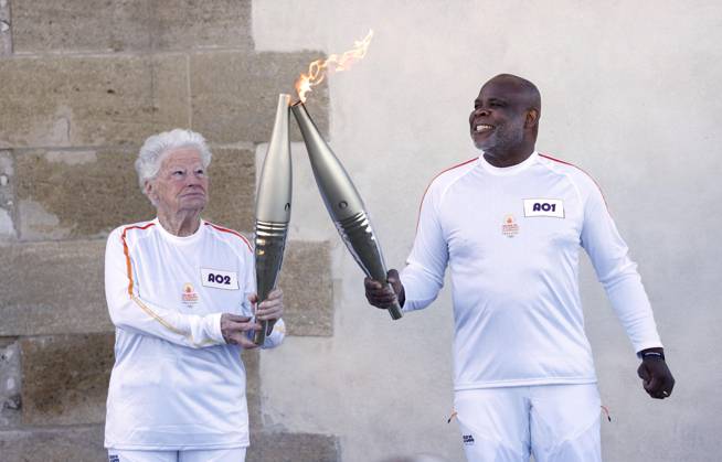 Paris Olympic torch relay begins Colette Cataldo (L) receives the Olympic flame from former French football player Basile Boli in Marseille on May 9, 2024, as the Paris Olympic torch relay begins following the arrival of the flame in the southern French port city on a majestic three-mast ship. About 10,000 torchbearers are to pass through over 400 towns until the games opening ceremony in Paris on July 26.  A14AA0002809100P