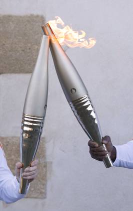Paris Olympic torch relay begins Torchbearers perform a torch kiss in Marseille on May 9, 2024, as the Paris Olympic torch relay begins following the arrival of the Olympic flame in the southern French port city on a majestic three-mast ship. About 10,000 torchbearers are to pass through over 400 towns until the games opening ceremony in Paris on July 26.  A14AA0002809163P