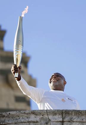 Paris Olympic torch relay begins Former French football player Basile Boli raises the Olympic torch in Marseille on May 9, 2024, as the Paris Olympic torch relay begins following the arrival of the Olympic flame in the southern French port city on a majestic three-mast ship. About 10,000 torchbearers are to pass through over 400 towns until the games opening ceremony in Paris on July 26.  A14AA0002809179P