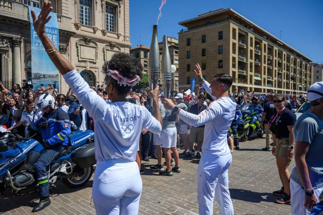 (240509) -- MARSEILLE, May 9, 2024 -- Dancer Maryam Kaba (L) passes the Olympic Torch to local firefighter Matthieu Gudet during the relay of the Olympic flame of Paris 2024 in Marseille, France, May 9, 2024. (Photo by Xinhua) (SP)FRANCE-MARSEILLE-2024 PARIS OLYMPIC-TOURCH RELAY JulienxMattia 