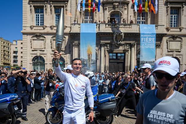 (240509) -- MARSEILLE, May 9, 2024 -- Local firefighter and torch bearer Matthieu Gudet holds the Olympic Torch during the relay of the Olympic flame of Paris 2024 in Marseille, France, May 9, 2024. (Photo by Xinhua) (SP)FRANCE-MARSEILLE-2024 PARIS OLYMPIC-TOURCH RELAY JulienxMattia 