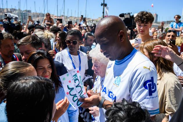 (240509) -- MARSEILLE, May 9, 2024 -- Former football player Didier Drogba signs for fans during the relay of the Olympic flame of Paris 2024 in Marseille, France, May 9, 2024. (Photo by Xinhua) (SP)FRANCE-MARSEILLE-2024 PARIS OLYMPIC-TOURCH RELAY JulienxMattia 