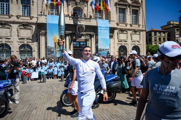 (240509) -- MARSEILLE, May 9, 2024 -- Local firefighter and torch bearer Matthieu Gudet holds the Olympic Torch during the relay of the Olympic flame of Paris 2024 in Marseille, France, May 9, 2024. (Photo by Xinhua) (SP)FRANCE-MARSEILLE-2024 PARIS OLYMPIC-TOURCH RELAY JulienxMattia 
