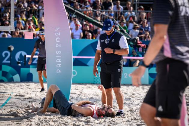 01 08 2024, Paris, Eiffel Tower Stadium Beach volleyball, Olympic Games, preliminary round Clemens Wickler GER trips over net camera and injures referee Giovanni Bake RSA with him