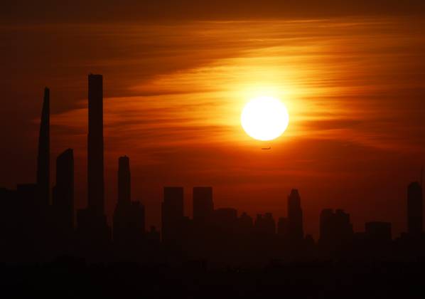 The sun sets behind the Manhattan Skyline from the top of Arthur Ashe Stadium in the first round of the 2024 US Open Tennis Championships in at the USTA Billie Jean King National Tennis Center on Tuesday, August 27, 2024 in New York City.  NYP20240827113 JOHNxANGELILLO