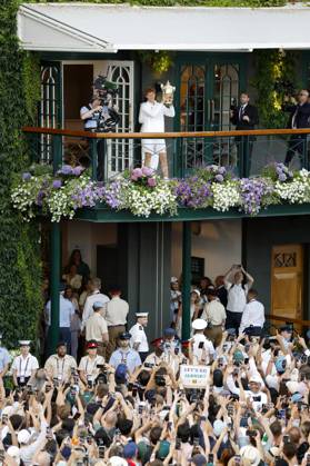 Tennis: Wimbledon championships Jannik Sinner (top) of Italy holds the victor s trophy after beating Carlos Alcaraz of Spain in the men s singles final at the Wimbledon tennis tournament in London on July 13, 2025.  A14AA0004721903P