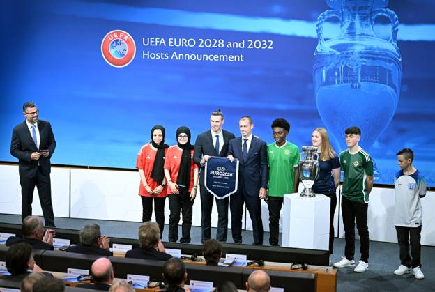 Ireland and United Kingdom confirmed to co-host 2028 UEFA European Football Championship GENEVA, SWITZERLAND - OCTOBER 10: UEFA President Aleksander Ceferin (4th L) and Welsh retired professional footballer, heading the delegation of UK and Ireland Gareth Bale (3rd L) hold the pennant as they pose with the pennant next to the trophy after United Kingdom and Ireland were elected to host the Euro 2028 football tournament during a ceremony held after the Executive Board meeting at the UEFA headquarters in Nyon, Geneva, Switzerland on October 10, 2023. Geneve Isviçre. Editorial use only. Please get in touch for any other usage. Copyright: x2025xAnadoluxDursunxAydemirx