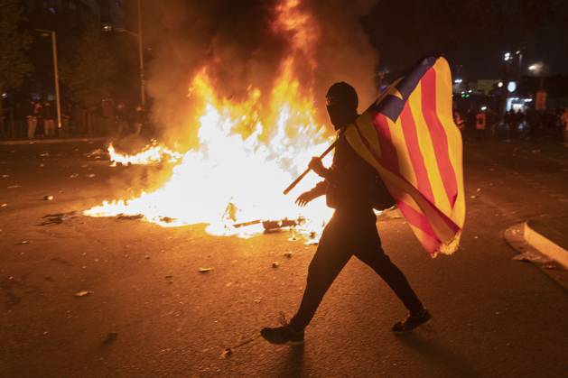 FC Barcelona, Barca v Real Madrid: La Liga BARCELONA, SPAIN - DECEMBER 18: A protester carries a Catalan pro-independence Estelada flag stands next to a burning barricade during a protest called by Catalan separatist movement Democratic Tsunami outside the Camp Nou stadium in Barcelona on December 18, 2019, during the El Clasico Spanish League football match between Barcelona FC and Real Madrid CF. Catalonia Spain. Editorial use only. Please get in touch for any other usage.  Copyright: x2025xAnadoluxAdriaxPuigx