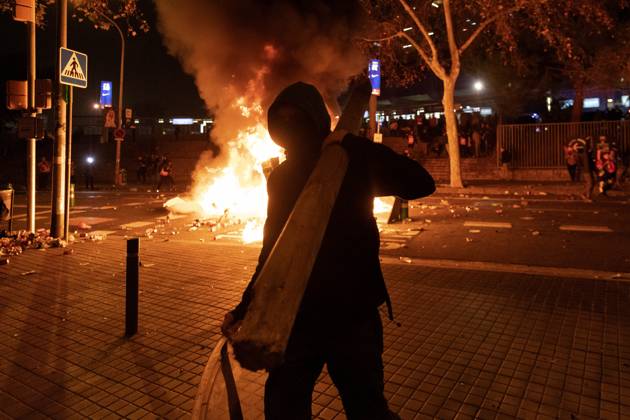 FC Barcelona, Barca v Real Madrid: La Liga BARCELONA, SPAIN - DECEMBER 18: A protester carries a wood near a burning barricade during a protest called by Catalan separatist movement Democratic Tsunami outside the Camp Nou stadium in Barcelona on December 18, 2019, during the El Clasico Spanish League football match between Barcelona FC and Real Madrid CF. Catalonia Spain. Editorial use only. Please get in touch for any other usage.  Copyright: x2025xAnadoluxAdriaxPuigx